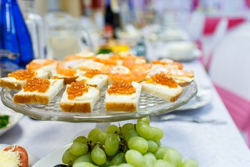 canape with red caviar on the plate on the wedding table