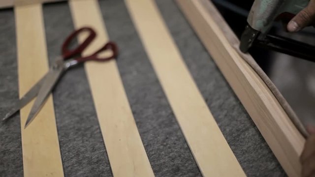 craftsman is working to build the sofa. manufacture of upholstered furniture.