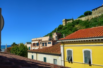 Fototapeta na wymiar Castiglione della Pescaia, Tuscany, Italy 18 August 2014, 5.00 pm. View from below, towards the top where the hill of the village and the castle stands out.