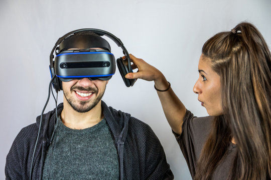 Junger Mann spielt mit Virtual Reality Datenbrille, Freundin beschwert sich