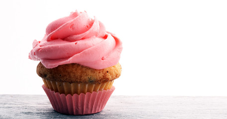 Tasty cupcakes on wooden background. Birthday cupcake in pink color