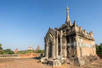 Fototapeta premium Old and small Mimalaung Kyaung Temple in Bagan, Myanmar (Burma) on a sunny day. Thatbyinnyu and other temples and pagodas are in the background.