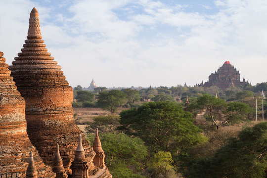 Two old and damaged brick stupas and Sulamani Temple at the Bagan Plain in Myanmar (Burma) on a sunny day, viewed from the Bulethi (Buledi) Temple.