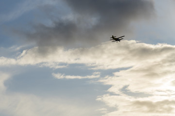 Naklejka na ściany i meble Old aircraft in clouds background