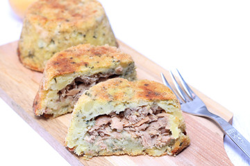 Potato pie with tuna on wooden chopping board