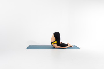 Sporty young woman doing yoga practice isolated on white background - concept of healthy life and...