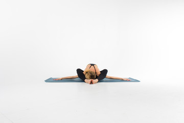 Sporty young woman doing yoga practice isolated on white background - concept of healthy life and...