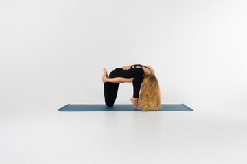 Sporty young woman doing yoga practice isolated on white background - concept of healthy life and...