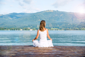 Woman meditating at the lake