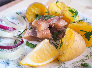 Herring with potatoes, onion and lemon. Rustic lunch.