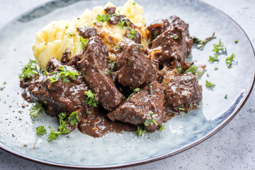 Fresh veal liver ragout in red wine sauce with mashed potatoes as close-up on a plate