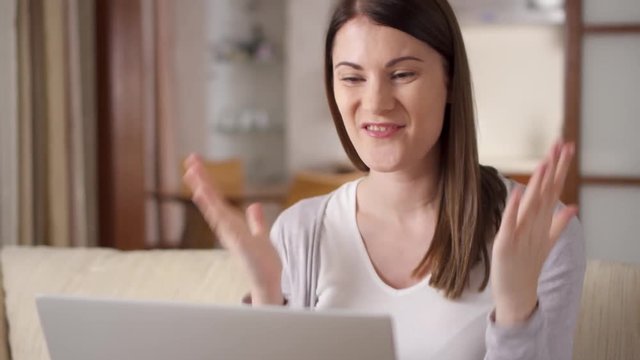 Young successful businesswoman using laptop at home living room home office, professional female employer recieving good news excited happy cheerful smiling. Success and achievement concept