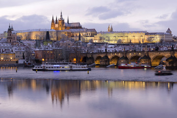 Evening colorful snowy Christmas Prague Lesser Town with gothic Castle and Charles Bridge, Czech republic