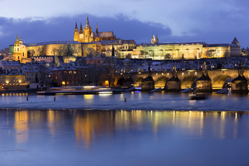 Evening colorful snowy Christmas Prague Lesser Town with gothic Castle and Charles Bridge, Czech republic
