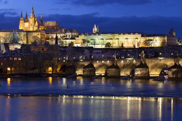 Evening colorful snowy Christmas Prague Lesser Town with gothic Castle and Charles Bridge, Czech republic