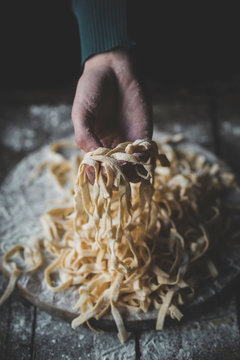 Female holding Italian traditional tagliatelle in her hands,selective focus