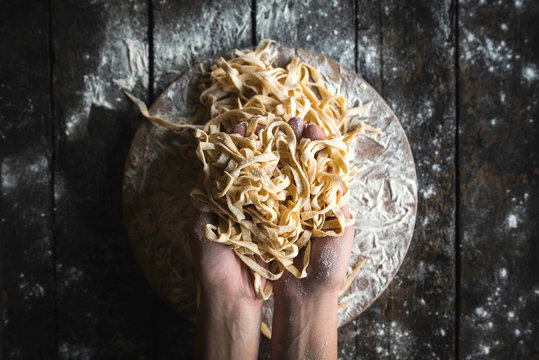 Italian traditional tagliatelle in female hands,selective focus