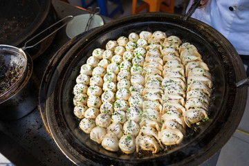 Sheng Jian Bao and Guo Tie being cooked - Shanghai pan fried dumplings in traditional pan - Full pan