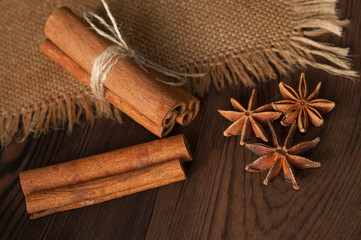 Cinnamon sticks and anise on sackcloth on a wooden background