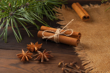 Cinnamon sticks and anise on sackcloth on a wooden background