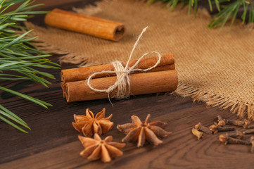 Cinnamon sticks and anise on sackcloth on a wooden background