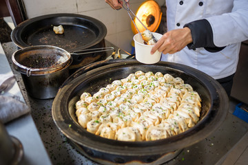 Sheng Jian Bao and Guo Tie being packaged - Shanghai pan fried dumplings in traditional pan