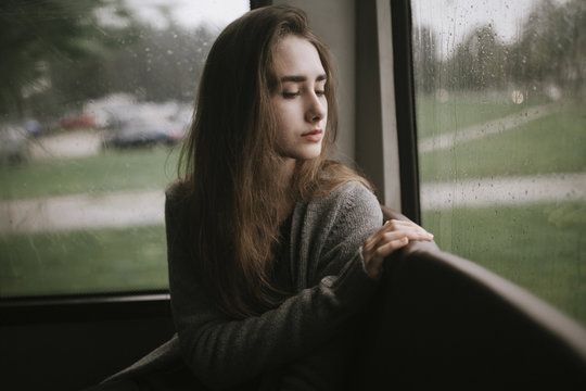Pensive Caucasian woman sitting on bus in rain