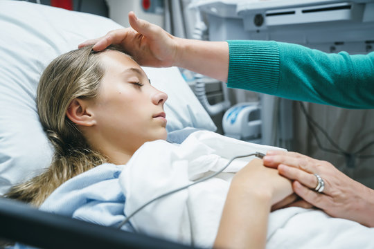 Doctor comforting patient in hospital bed