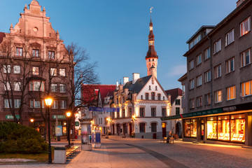Beautiful illuminated street of Medieval Old Town and Town Hall in the morning blue hour, Tallinn, Estonia