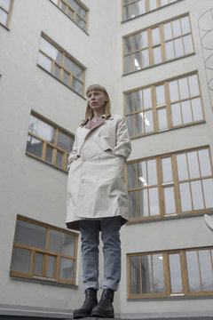 Caucasian woman wearing a coat near building