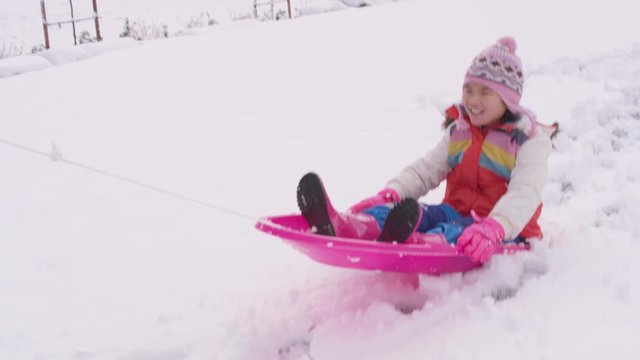 Kids Playing And Pushing Sled In Winter Snow