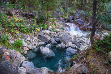Blue pool with natural hot stream water near mountain river in Hoytogol, Buryatia, Eastern Sayan