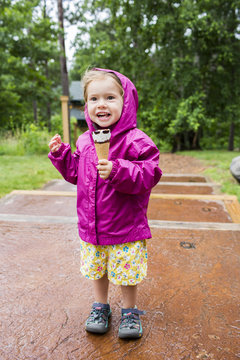 Smiling Caucasian girl eating ice cream cone