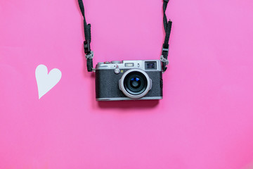 Vintage photo camera on Valentine's Day pink background with composition of blank photo frames and...