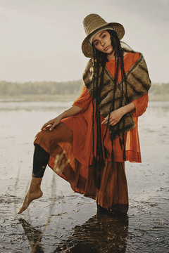 Caucasian woman wearing traditional clothing wading in water