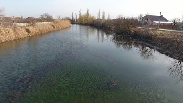 River eric current in the village in the spring. Shallow river, slowly flowing in the village