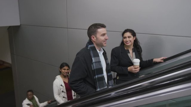 Businesspeople on escalator talking
