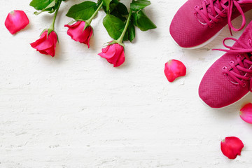 Red sport shoes  and red roses on white wooden background, Valentines sports background and...