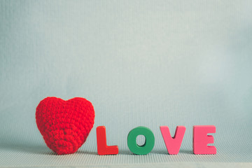 Valentine card with Love text and red knitting heart on blue background and copy space for add text and picture, love and valentine day concept.