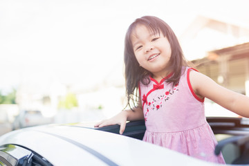 Vacations And Tourism Concept,Happy Little girl in the car on sunroof.