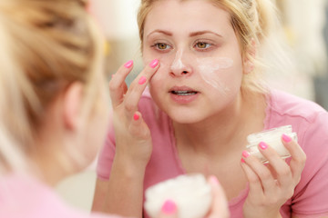Woman applying face cream with her finger