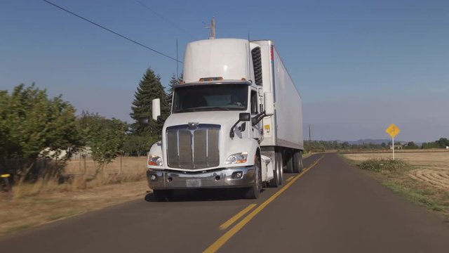 Semi truck driving on rural road.  Fully released for commercial use.