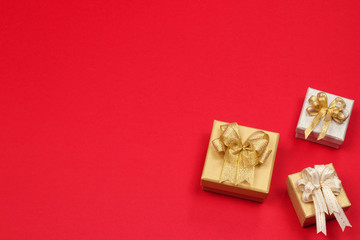 Gold and silver gift box on red background with copy space. Close up. Top view. Happy new year. Valentines day background.