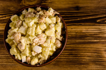 Salad with the haricot beans and meat dressed with mayonnaise in ceramic bowl. Top view