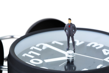 Figure miniature businessman or small people standing with alarm clock, time for business financial concept.