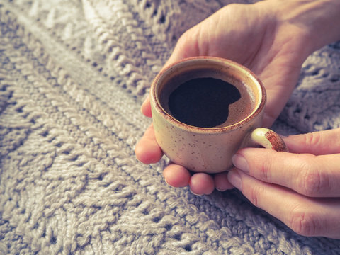 A Cup of espresso in a winter sweater. The concept of home comfort, coziness and warmth.
