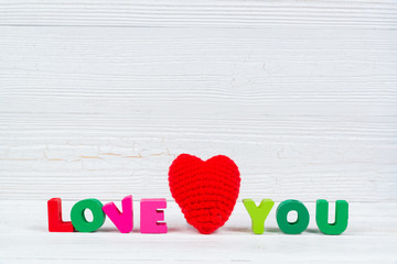 Valentine card with Love you text and red knitting heart on white wooden background and copy space for add text and picture, love and valentine day concept.