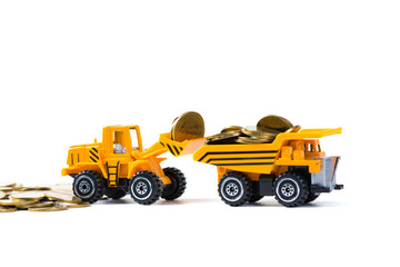 Mini bulldozer truck loading stack coin with pile of gold coin, isolated on white background with copy space, business finance and banking industrial concept.