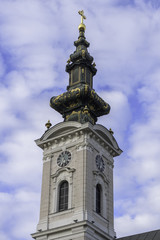 Obraz premium Church tower of Saint George's Cathedral in city of Novi Sad, Serbia against blue sky and clouds