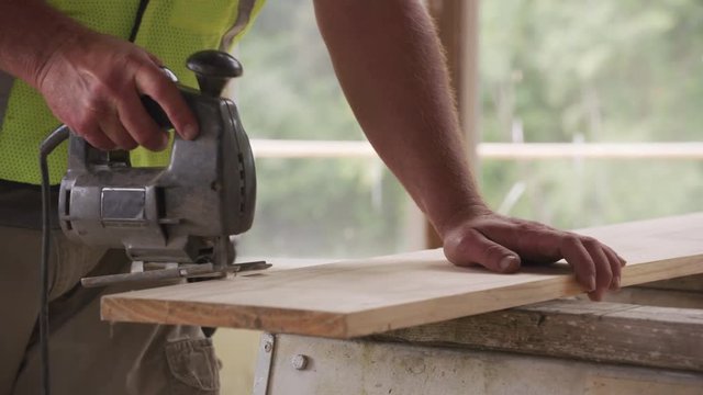Closeup of construction worker using jigsaw